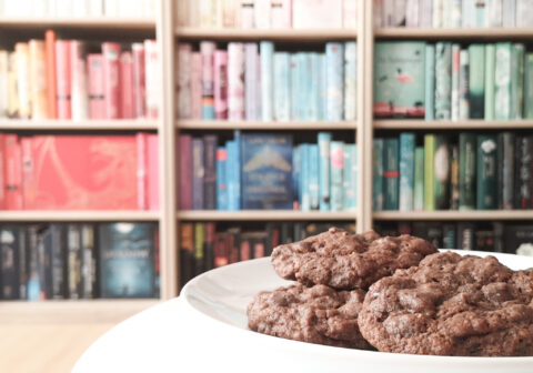 Teller mit Cookies vor Bücherregal im Hintergrund